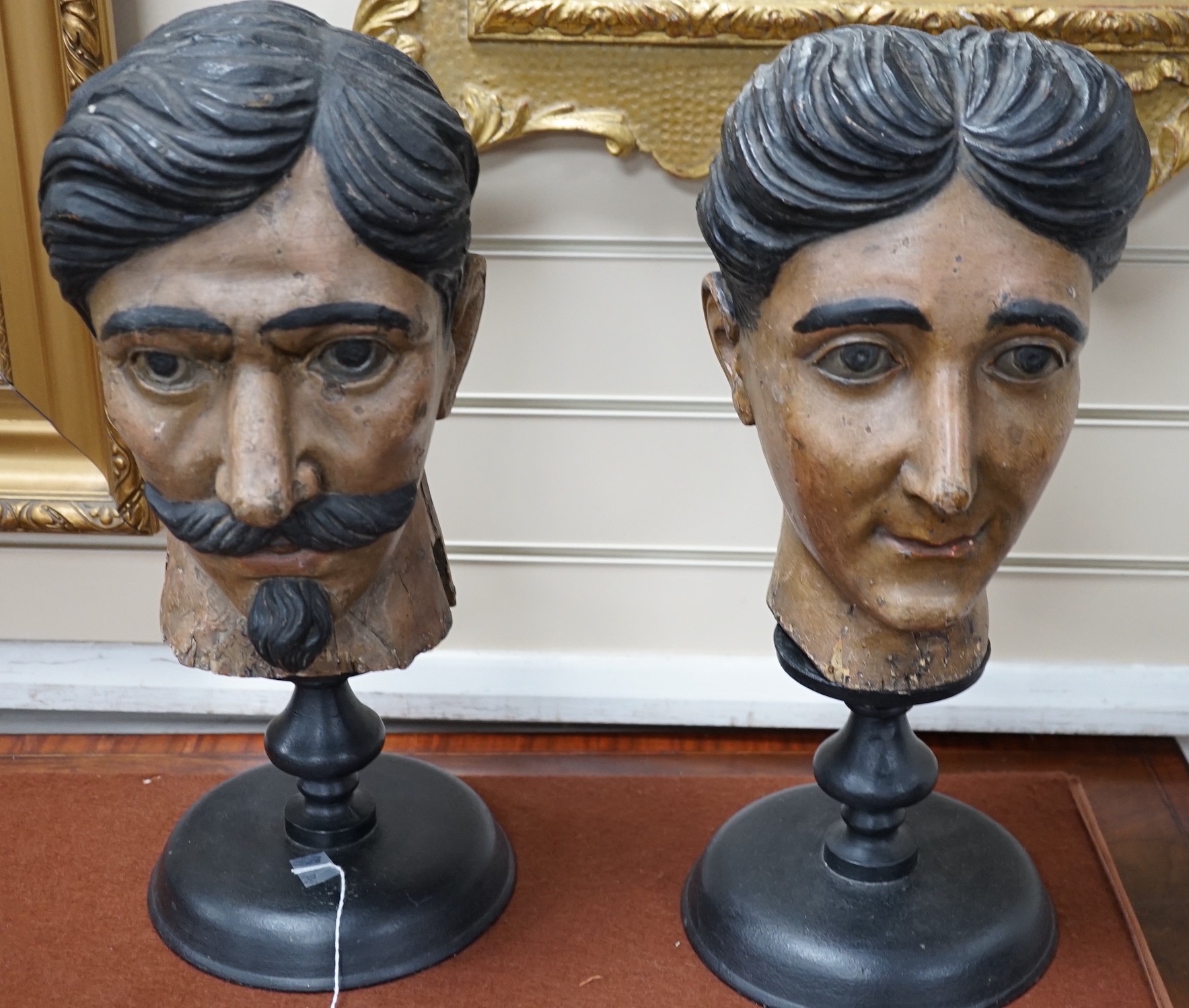 Two 20th century Italian carved and painted wooden heads on stands, 47cm